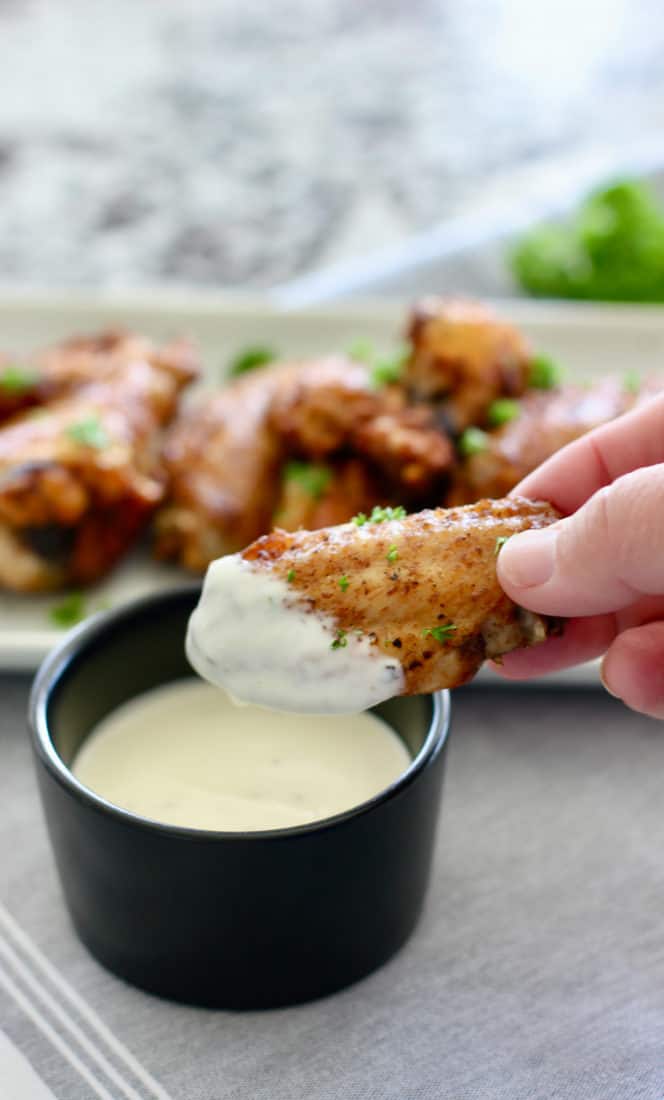 cooked chicken wing dipped into blue cheese