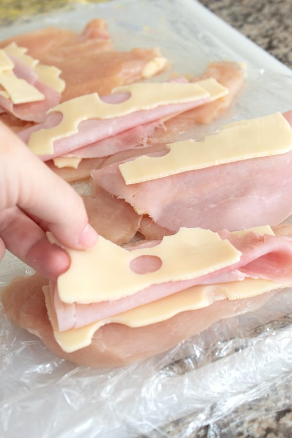 adding ham and Swiss to chicken breast cutlets before rolling them