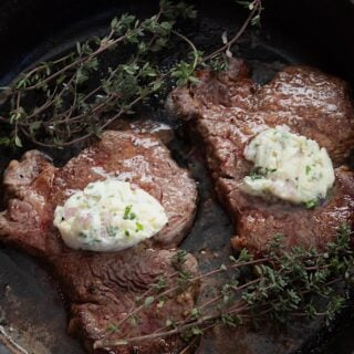 overhead view of steak in a pan with compound butter