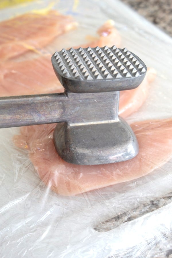 using a meat tenderizer to pound chicken