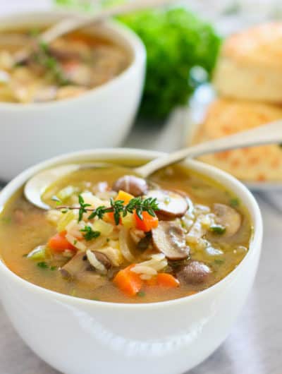 chicken and mushroom soup in a white bowl with spoon