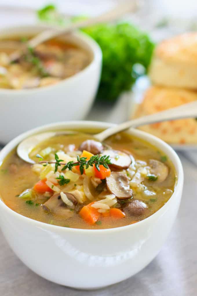 chicken and mushroom soup in a white bowl with spoon