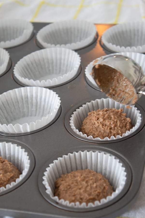 spooning batter into muffin tins