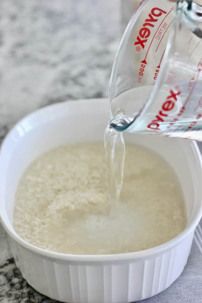 white rice and water in a baking dish