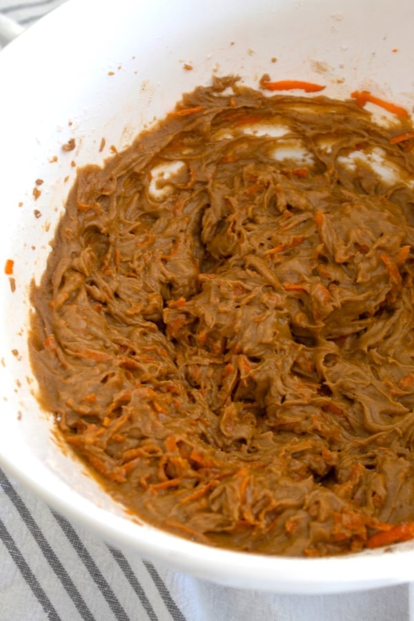 a white ceramic bowl with carrot cake batter