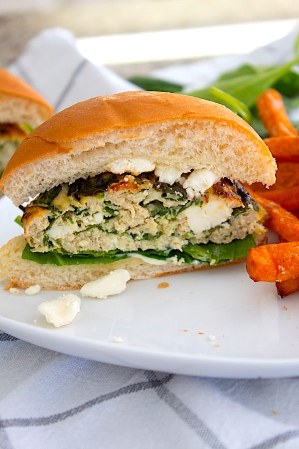 spinach feta burger cut in half with sweet potato French fries