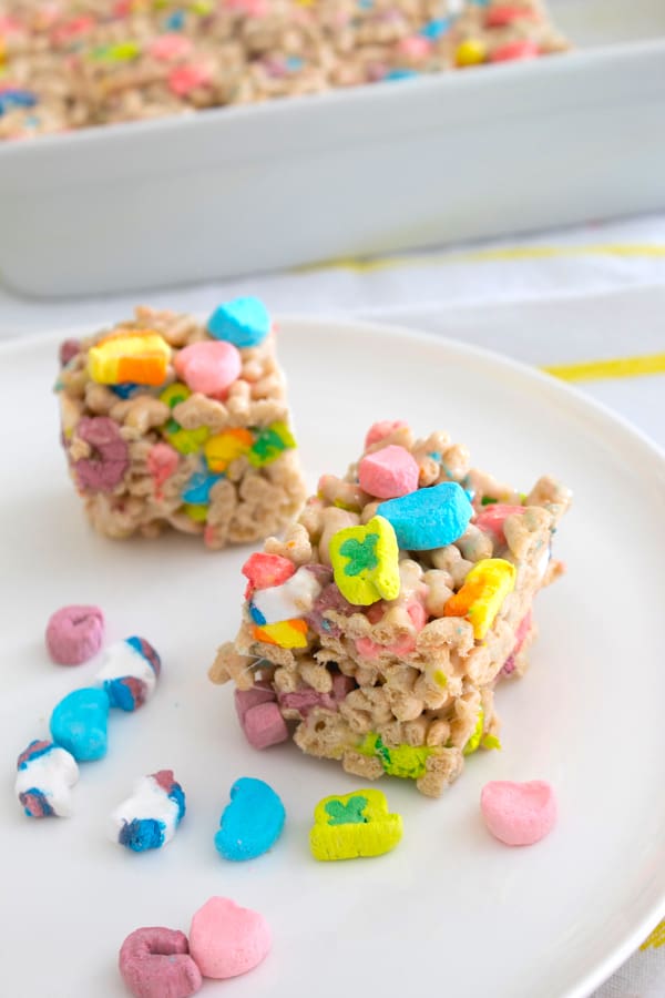 lucky charms cereal bars on white plate with marshmallows scattered