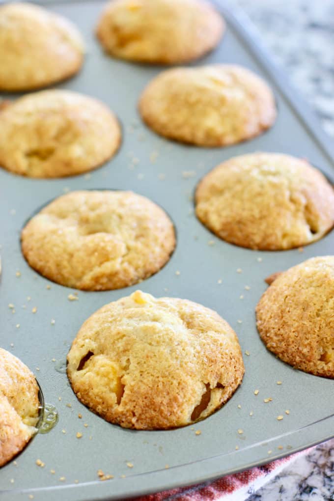 peach cobbler muffins in a muffin tin