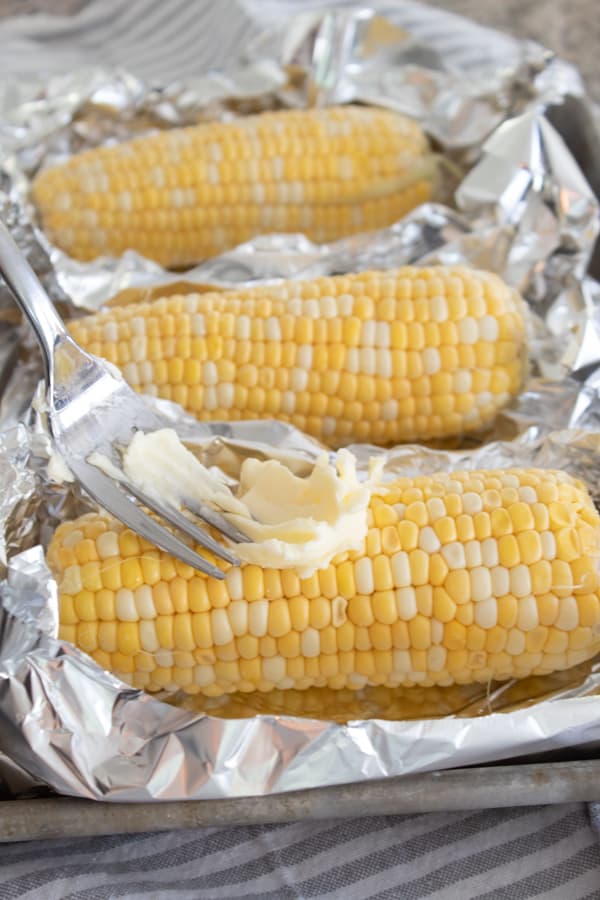 adding butter to raw corn