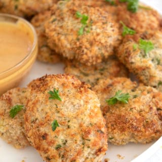 air fryer chicken nuggets on aw white plate with sauce in a dish