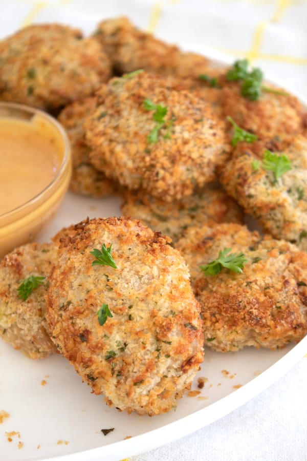 air fryer chicken nuggets on aw white plate with sauce in a dish