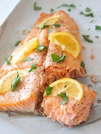 overhead view of salmon filet with lemon and parsley garnish