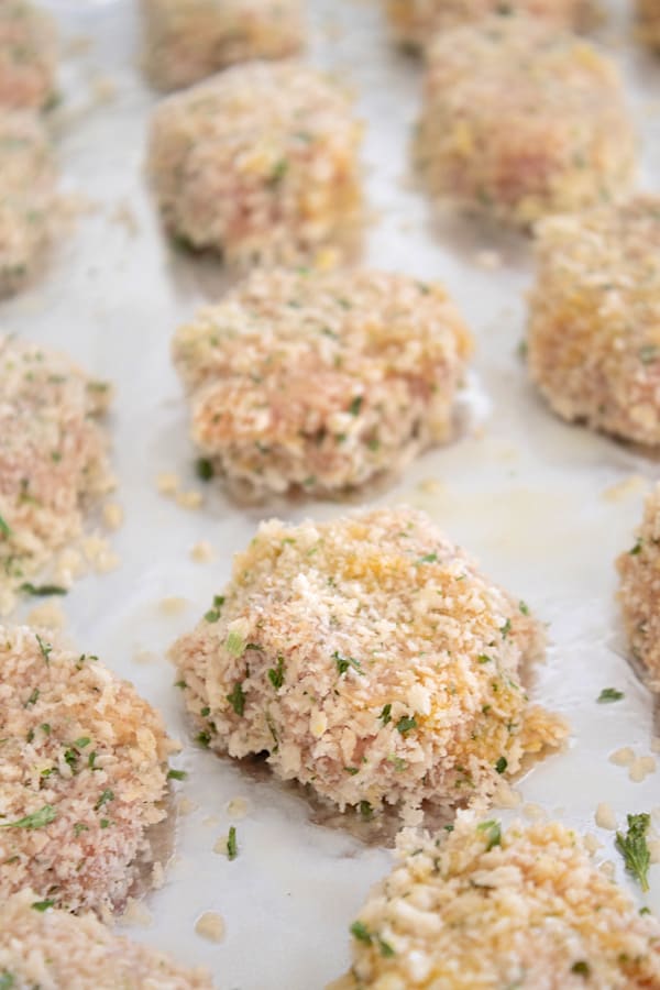 chicken nugget patties lined up on a sheet pan