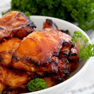 bbq chicken in a white dish with parsley garnish