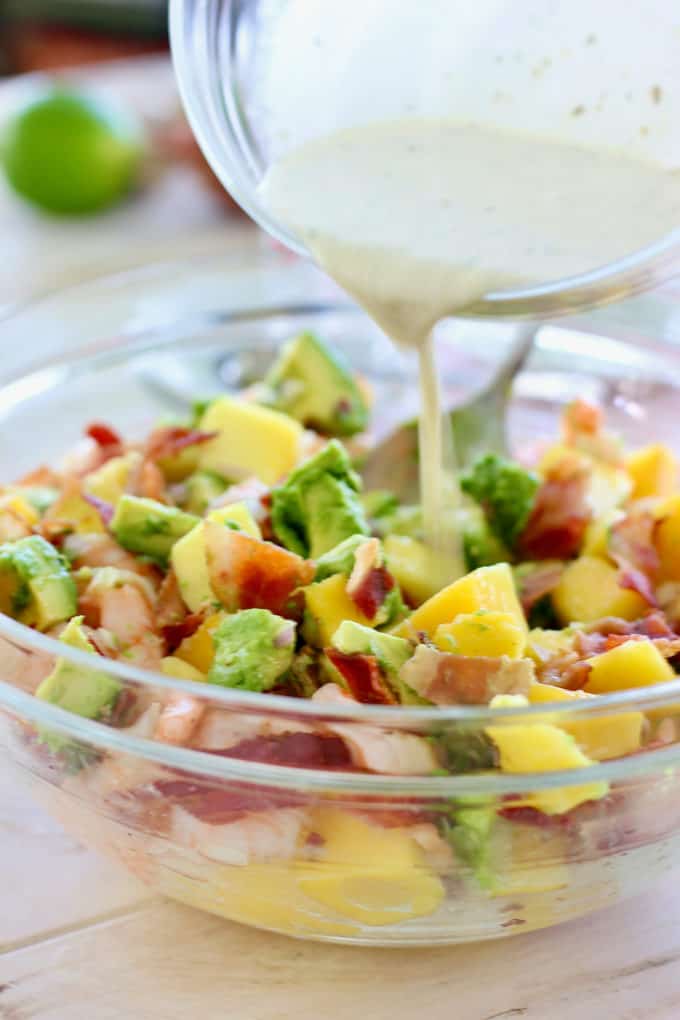 citrus dressing being poured over salad