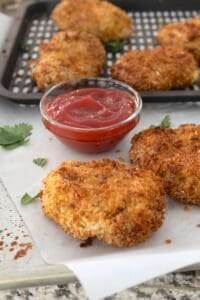 side view of air fryer chicken nuggets on a piece of parchment