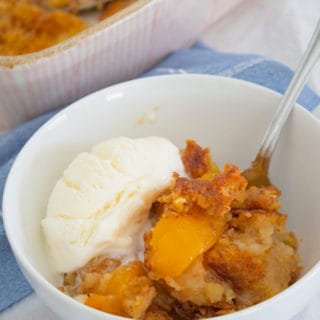 bowl of peach dump cake with ice cream