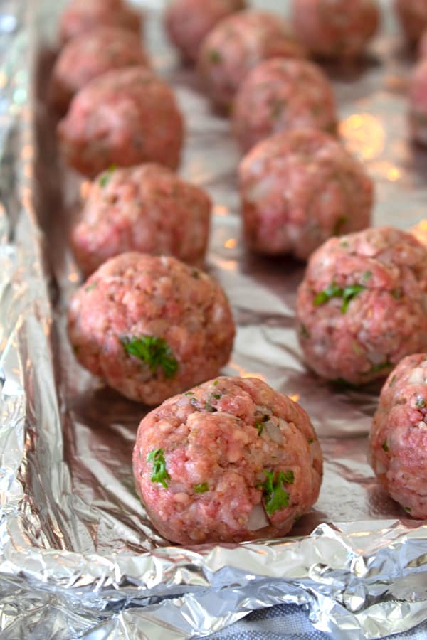 raw meatballs on a sheet pan ready to be baked