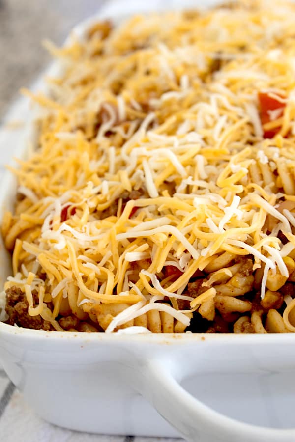 adding melted cheese to taco pasta casserole