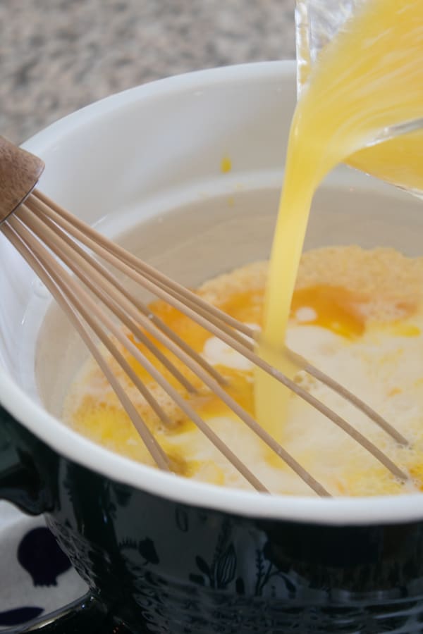 mixing cornbread batter in forest green mixing bowl