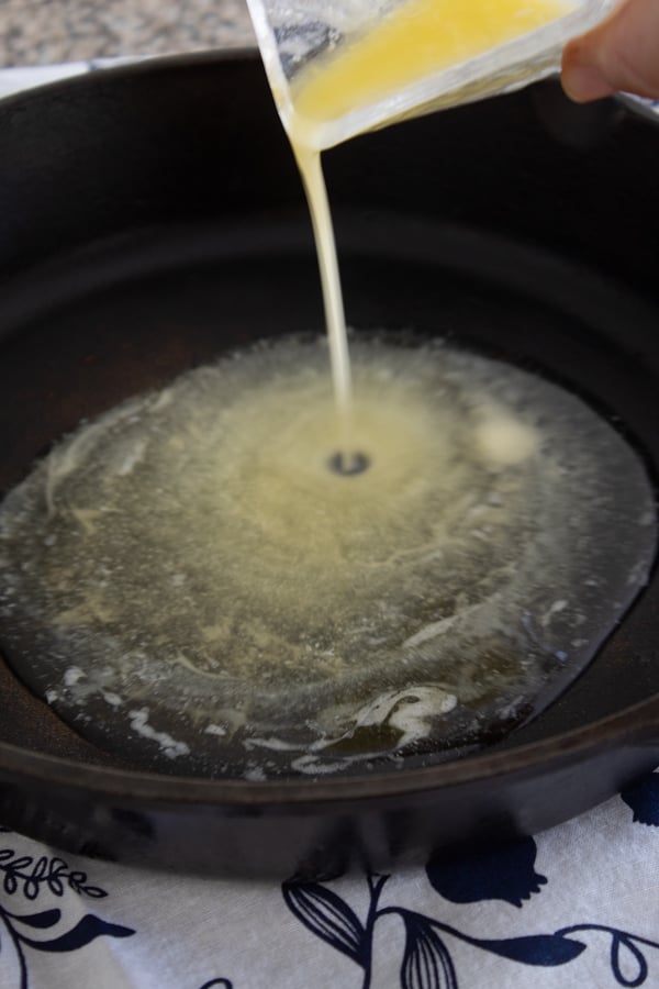 adding butter to hot cast iron pan