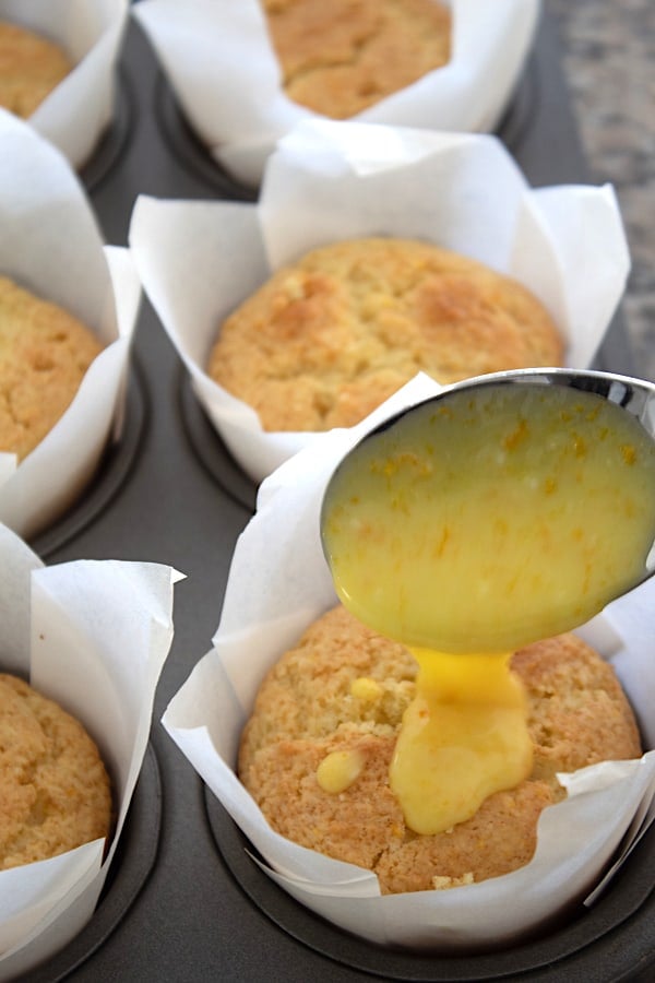 spooning glaze on orange muffins