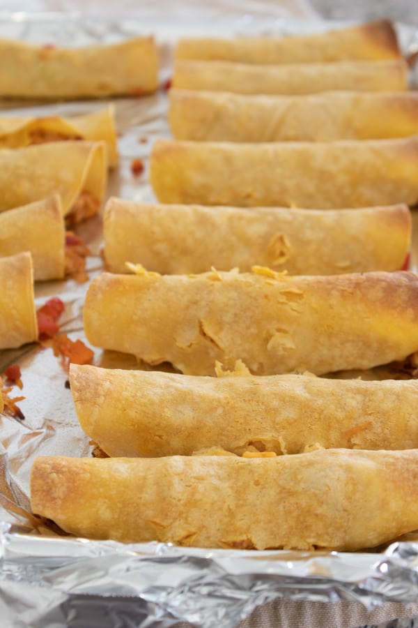 baked chicken taquitos on a baking sheet