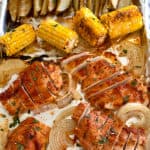 overhead view of sheet pan chicken dinner with corn and potato wedges