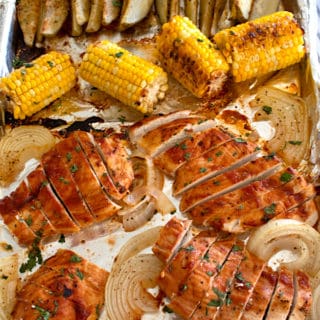 overhead view of sheet pan chicken dinner with corn and potato wedges