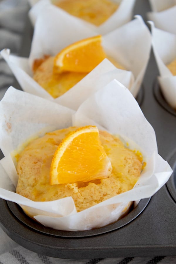 orange muffins garnished with an orange slice 