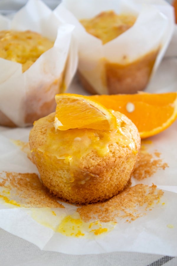 orange muffin out of its wrapper garnished with an orange slice