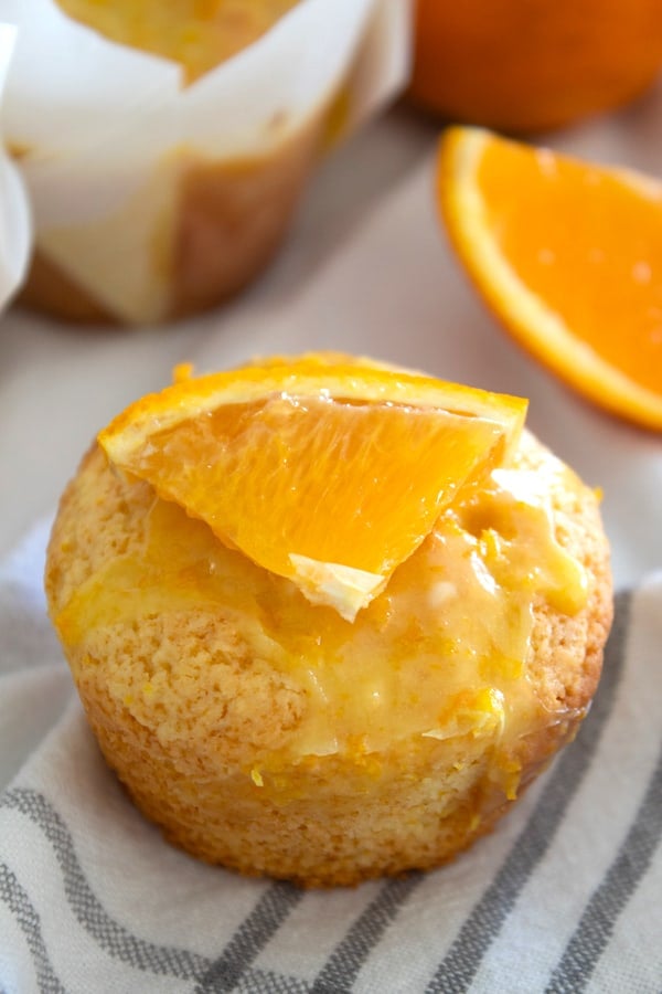 overhead view of orange muffin garnished with slice of orange