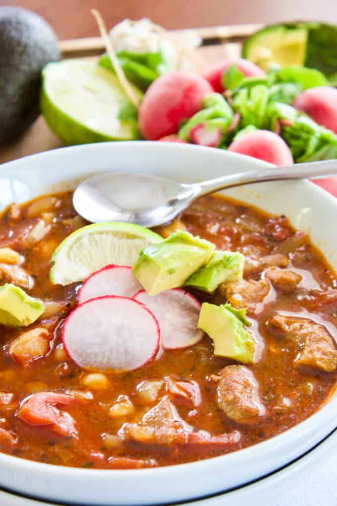 Pork Posole with radishes in a white bowl