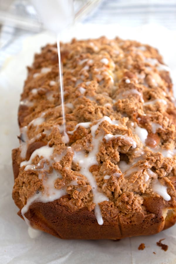 apple bread with glaze being drizzled