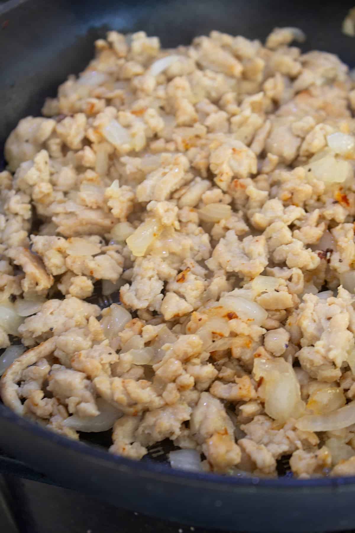 ground chicken sautéed in a pan with onion