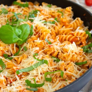 ground chicken pasta skillet in a black pan garnished with basil