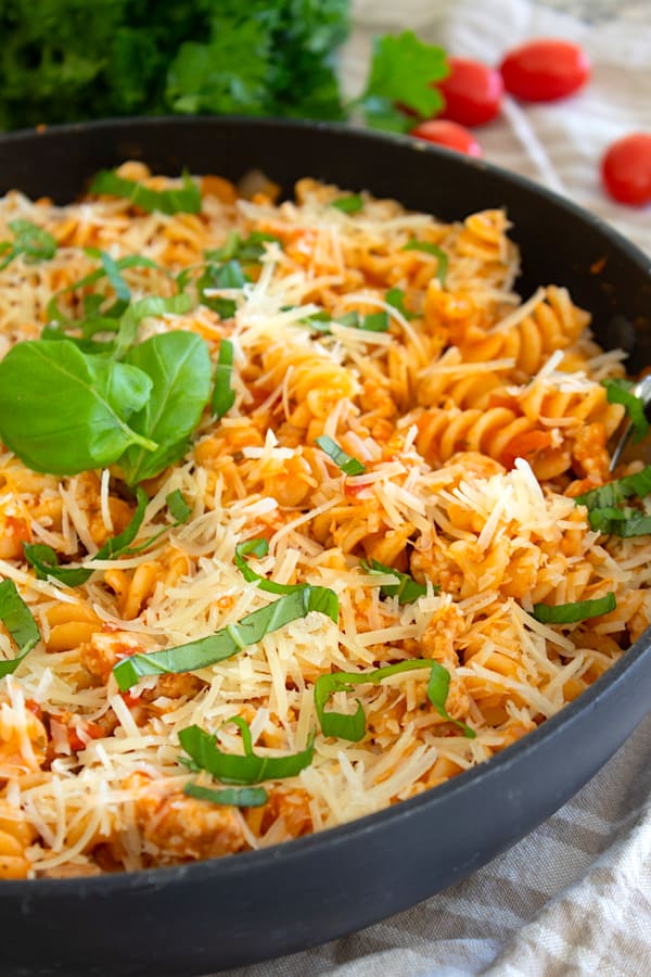 ground chicken pasta skillet in a black pan garnished with basil