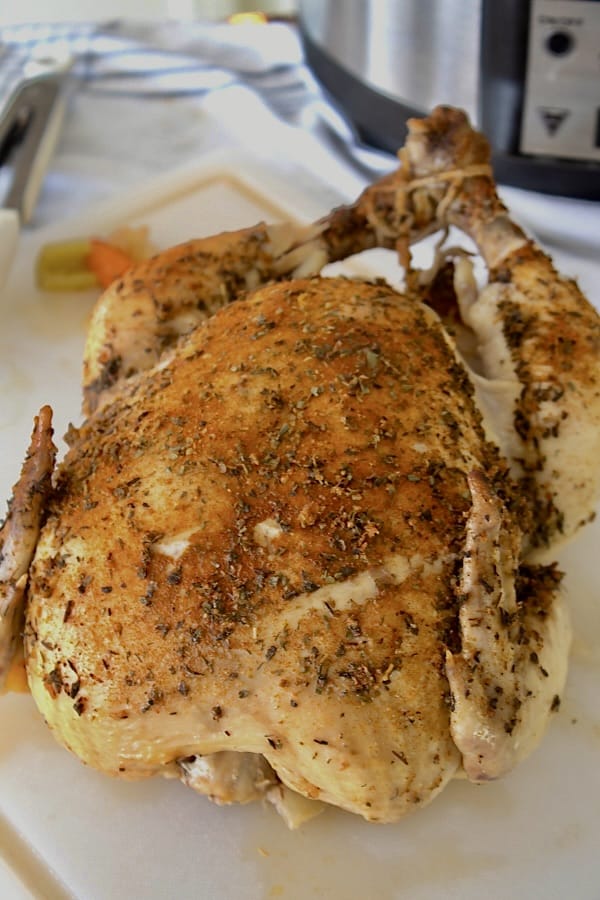 whole roast chicken on a white cutting board