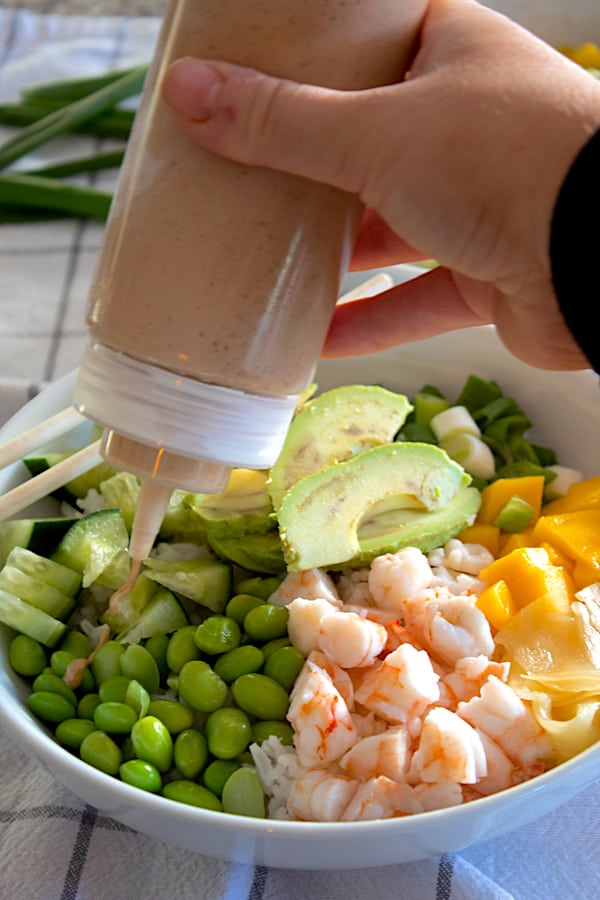 adding sauce to poke bowl