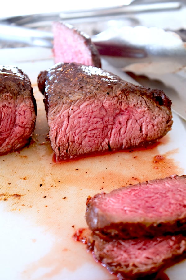 slicing steak on a cutting board