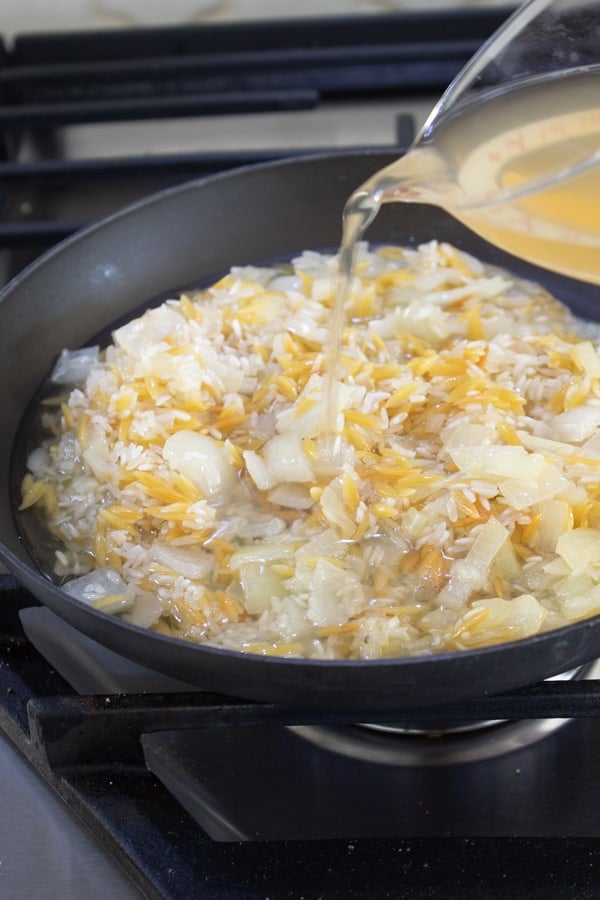 adding chicken broth to rice pilaf