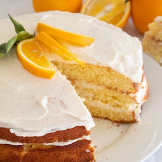 round layered cake with frosting naked style and orange slice garnish