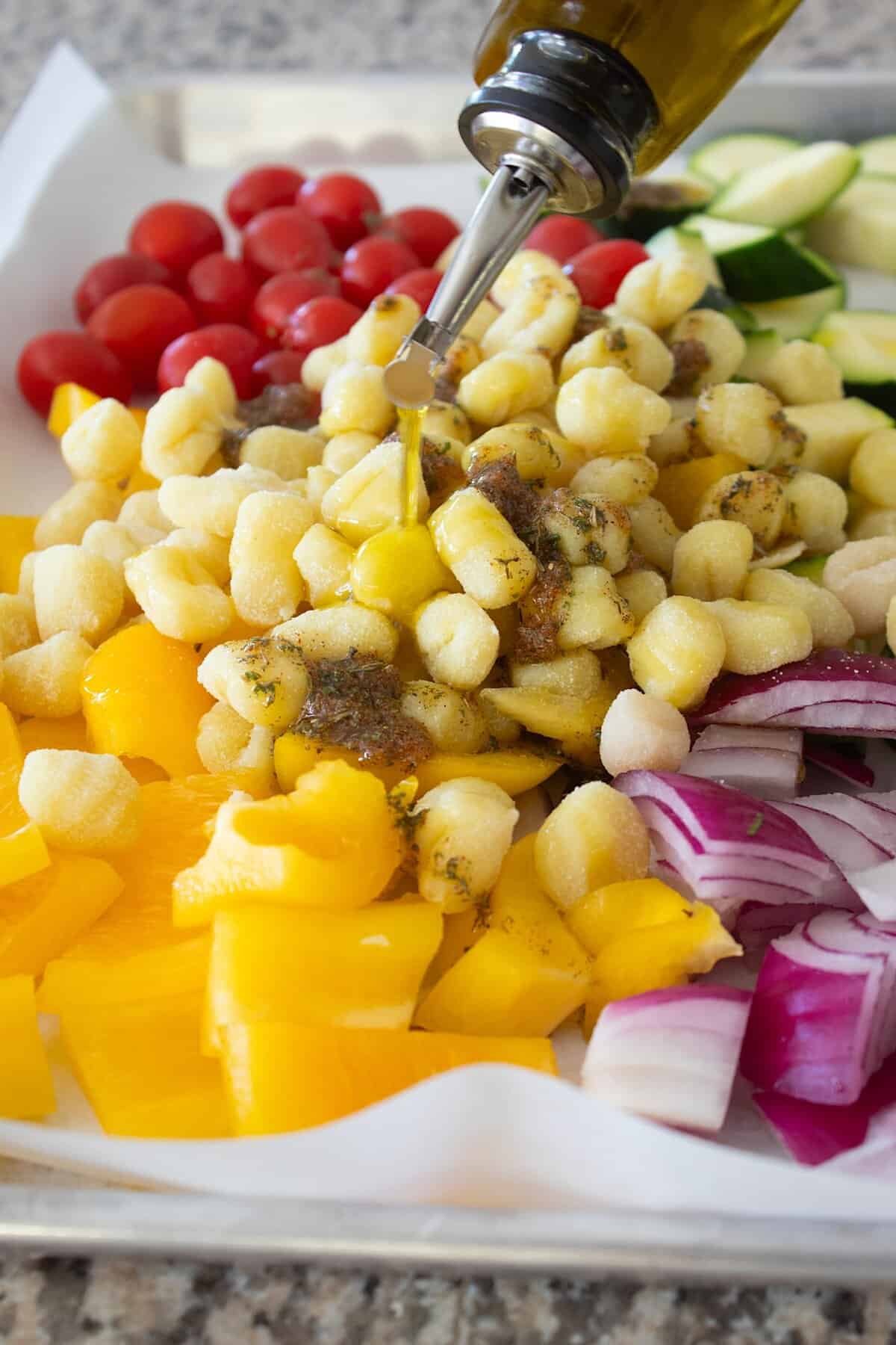 drizzling vinaigrette onto sheet pan gnocchi dinner
