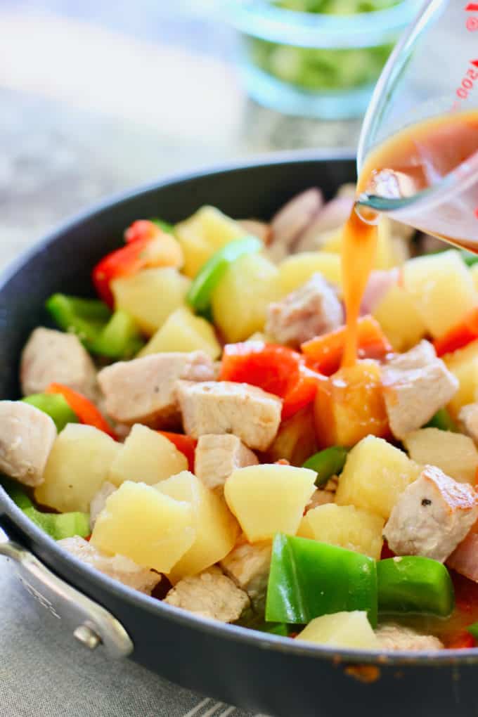 sauce being poured over pork dish