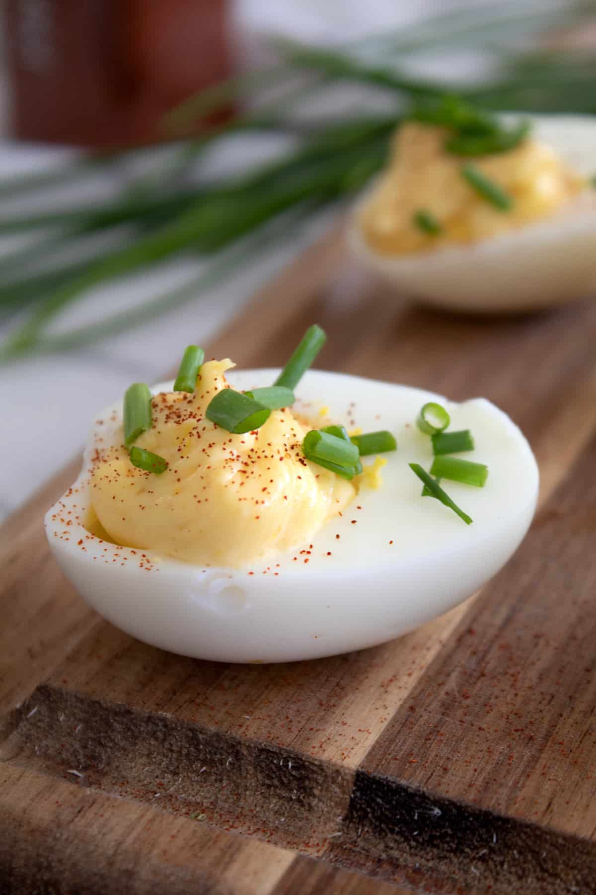 deviled egg on cutting board garnished with chives