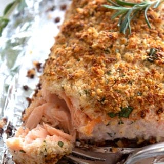panko crusted salmon on a sheet pan with a bite and fork taken out of it