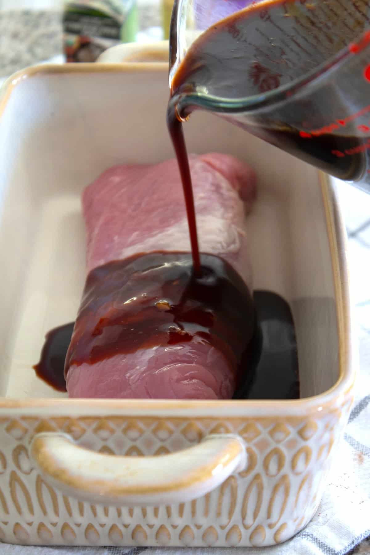 pouring marinade over pork loin