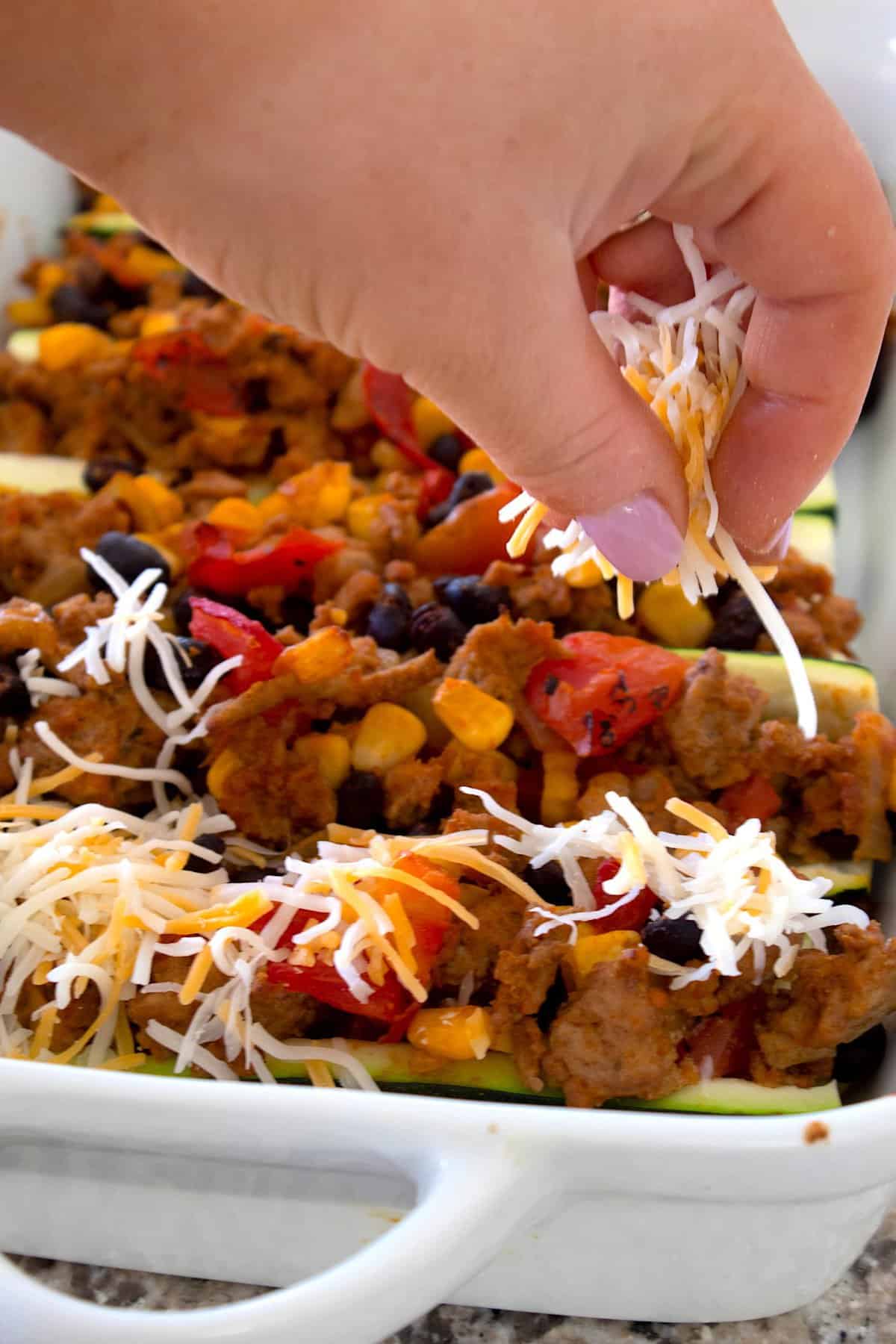 topping filled taco boats with cheddar cheese