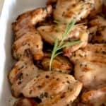 casserole pan full of cooked grilled chicken garnished with rosemary sprig