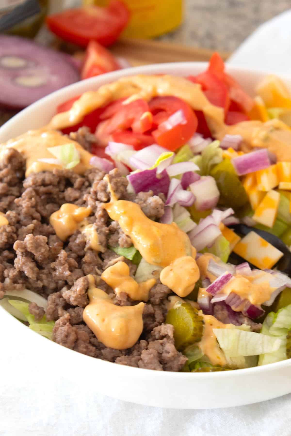 side view of burger salad in a bowl